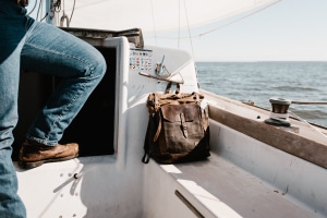 Man's leg in boat beside his duffel bag